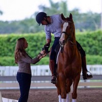 Bethany Peslar helps Team Off the Record's coach, Endel Ots, play the team's music for the quadrille from his phone